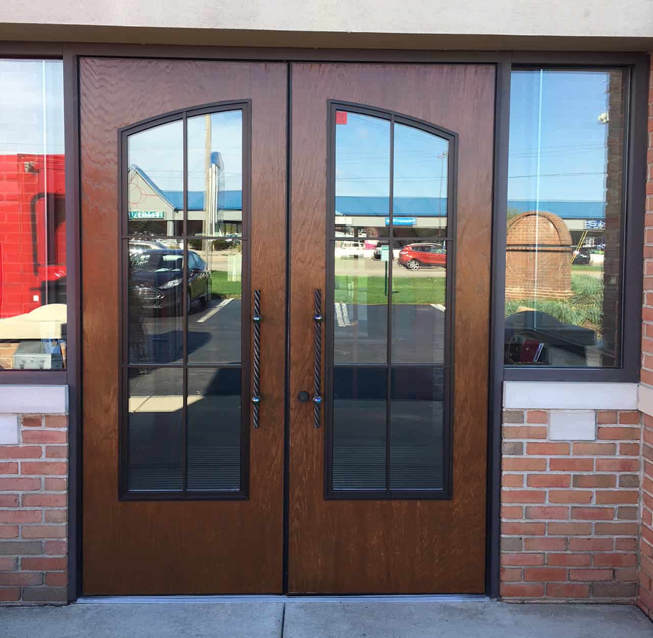 A custom wooden grain door with a curved lite kit.
