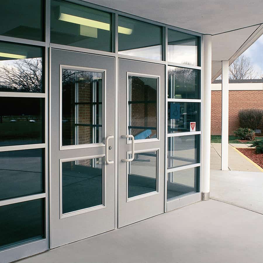 A school building with glass doors and glass windows.