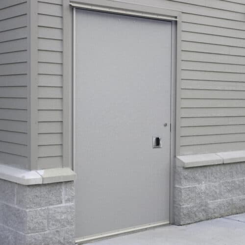 A grey building with a grey HMR-FRP door.