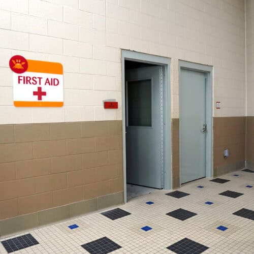 A hallway featuring a first aid station identified by a sign with a red cross and text 