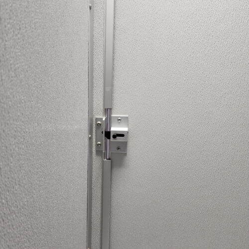A close-up image of a silver lock on a white door, with a small keyhole visible, against the textured background typical of commercial bathroom partitions.