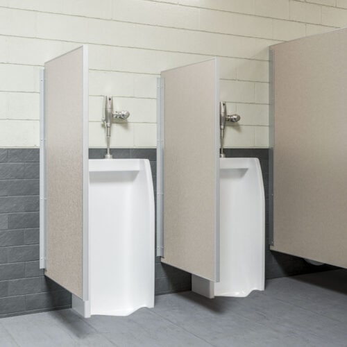 Two white urinals with commercial bathroom partitions offer privacy in a public restroom adorned with tiled walls and floors.