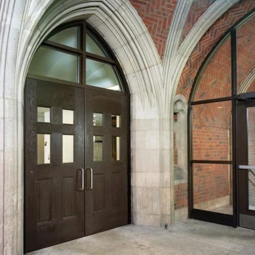 The entrance to a brick building with arched windows.