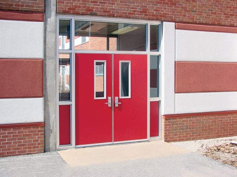 A red and white building with a red door.