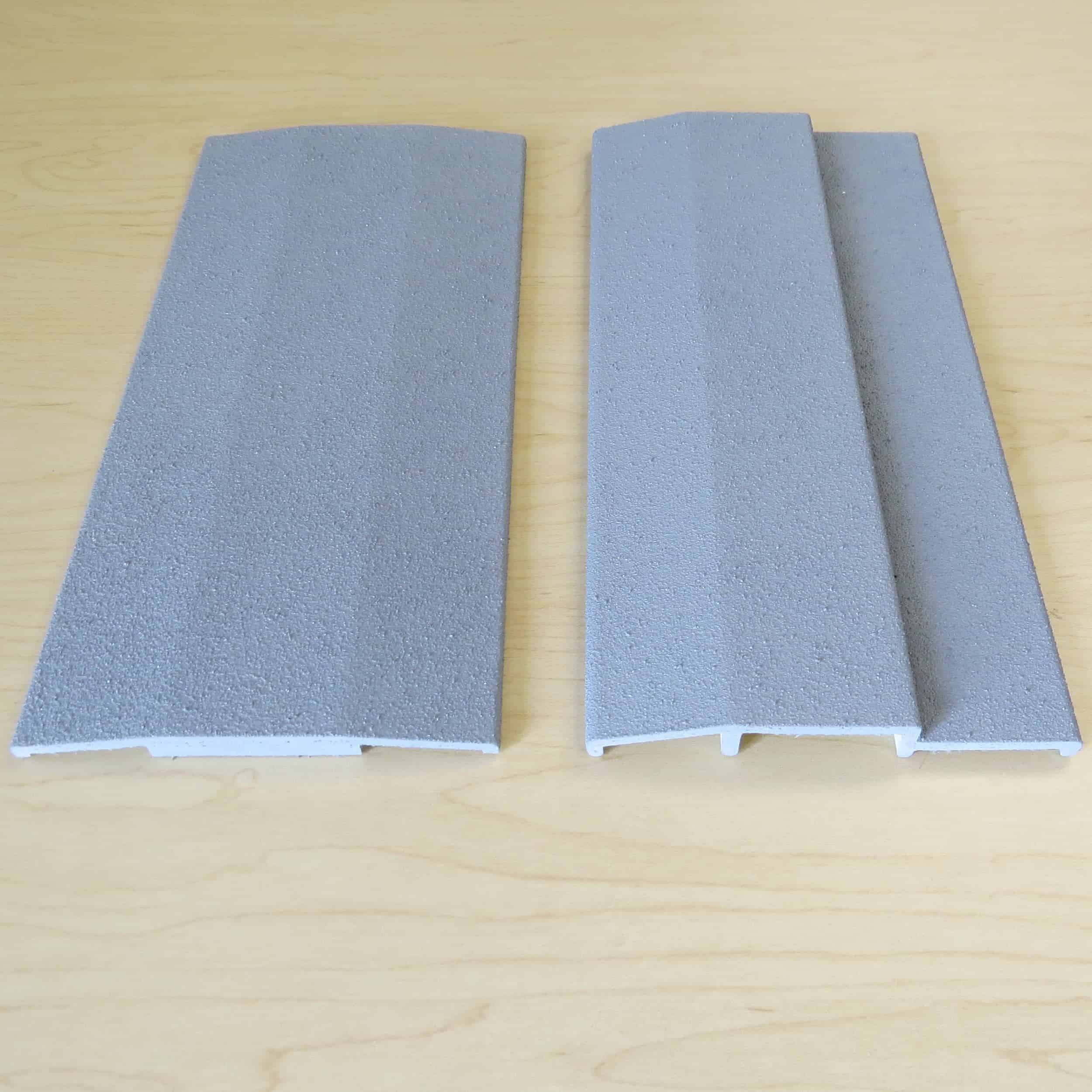 Two pieces of gray plastic on a wooden table.