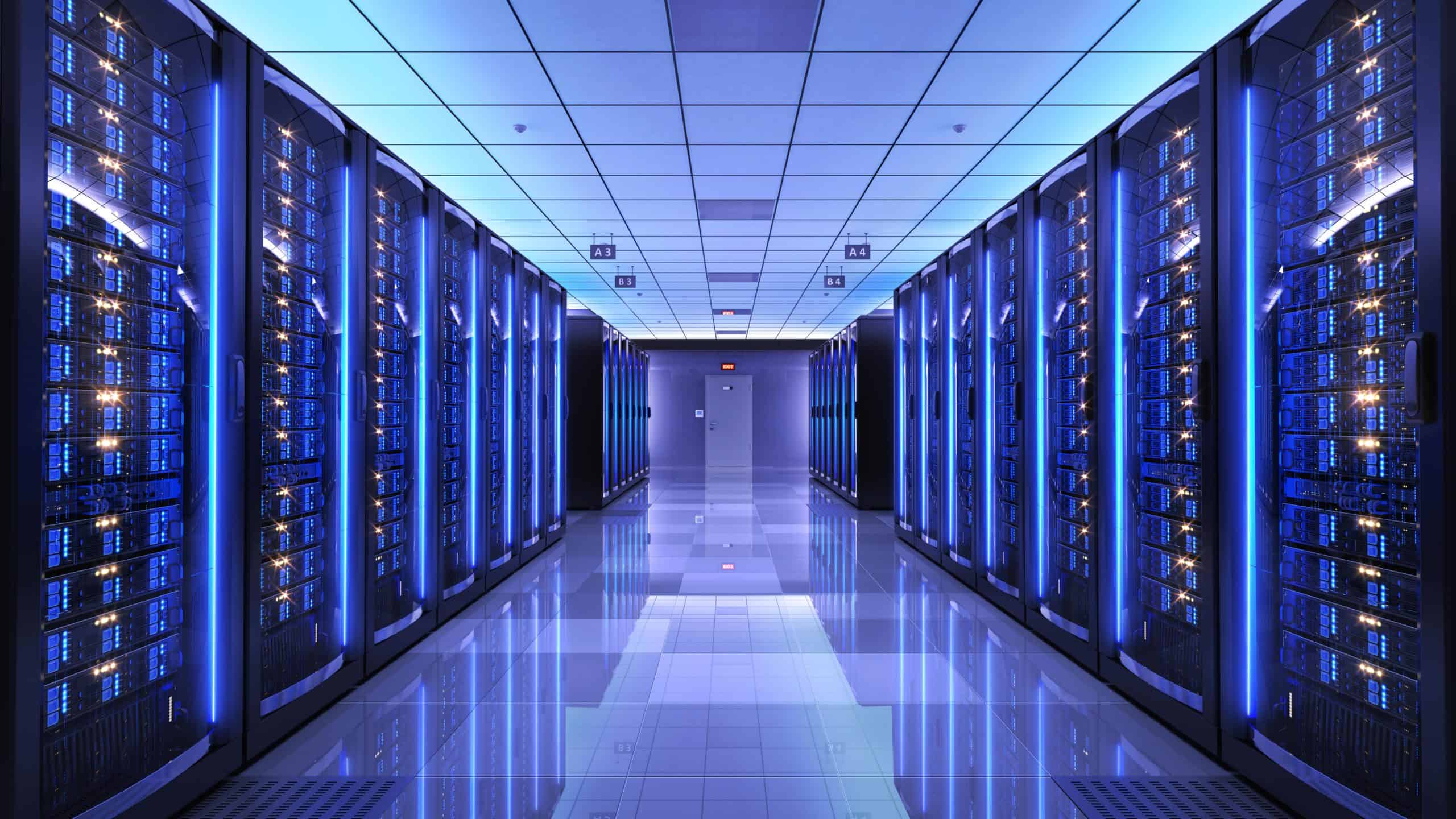 A server room featuring blue lights protected by fiberglass doors.