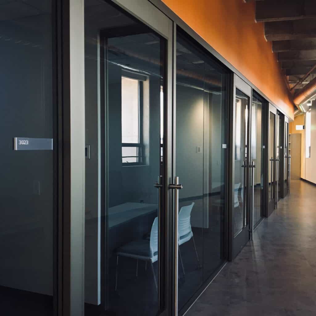 A hallway with glass doors and orange walls.