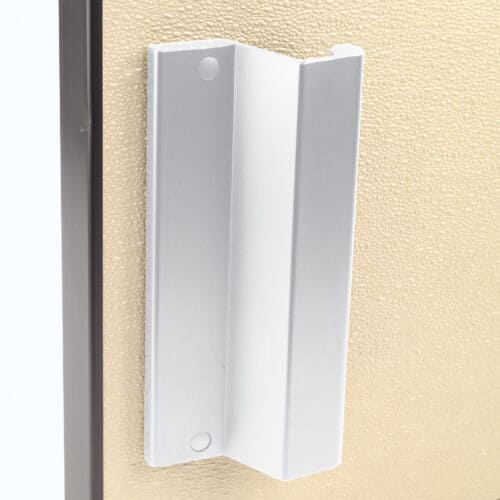 A white door handle on a beige wall.
