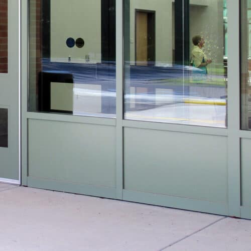 A school building with an SL-36 glass door and Aluminum Architectural Panels.