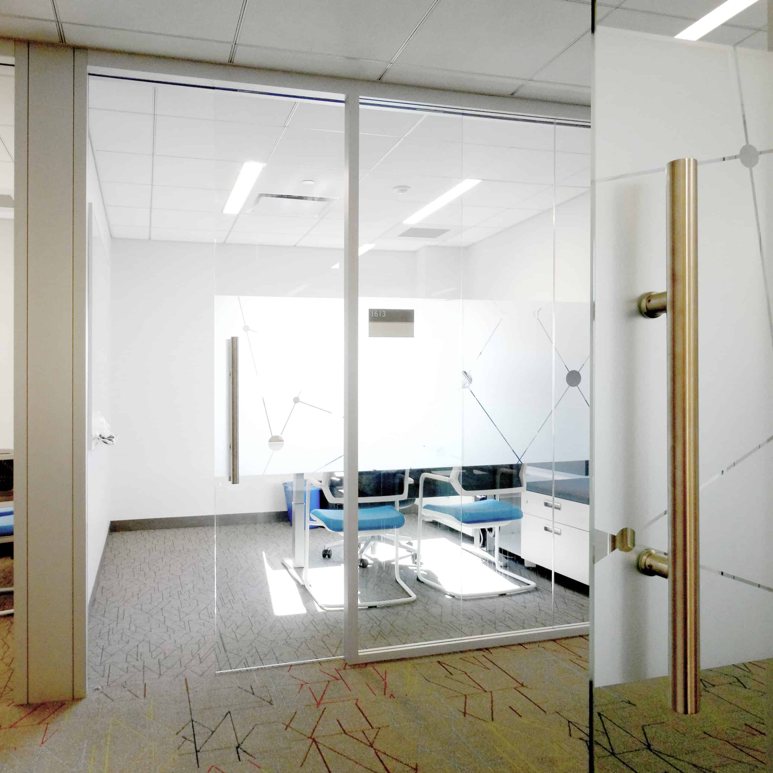 An office with a glass door and a desk.