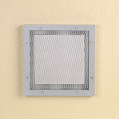A square metal plate on a beige wall.