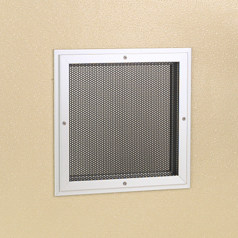 A square metal grille on a beige wall.