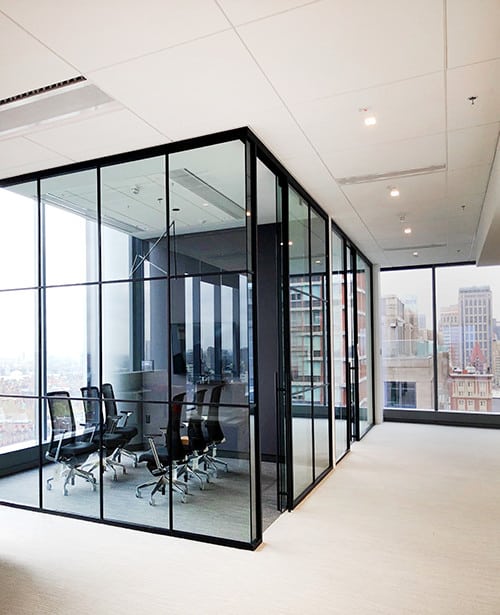 Glass walled office with sliding door system and a view of the city.
