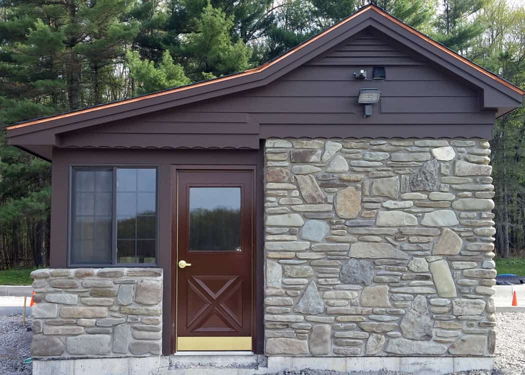 A small stone building equipped with a door and window.