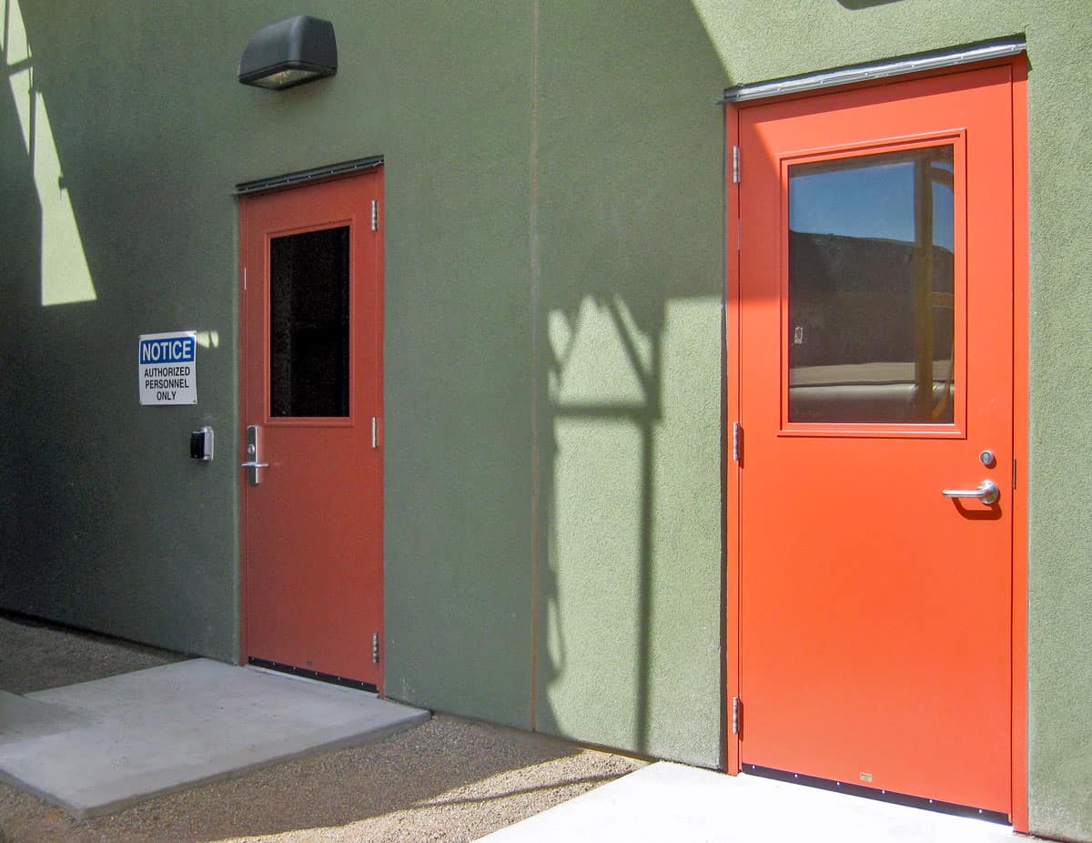 Two orange doors in front of a water treatment building.