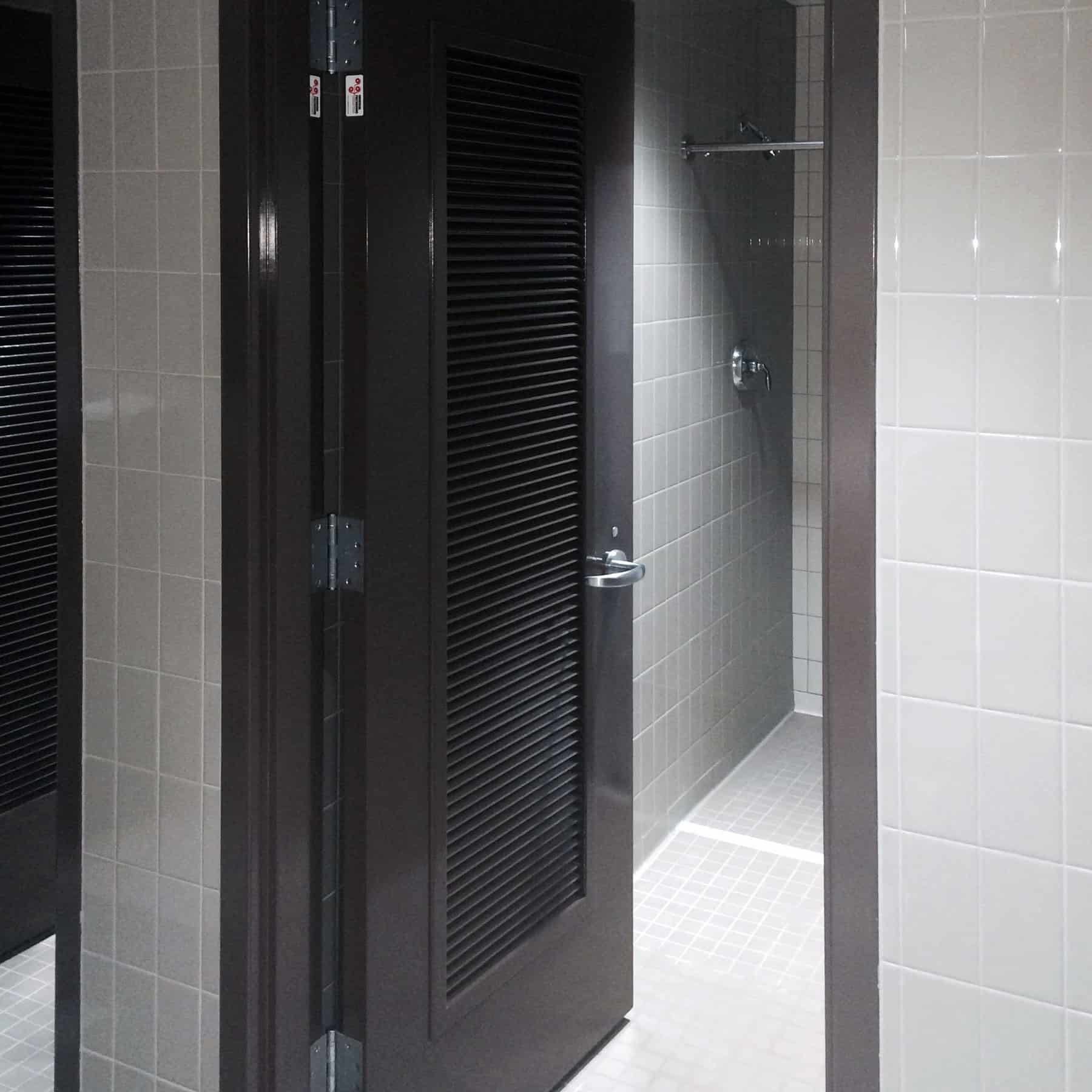 A bathroom with a black door that has undergone required ASTM E-84 testing for fiberglass doors.