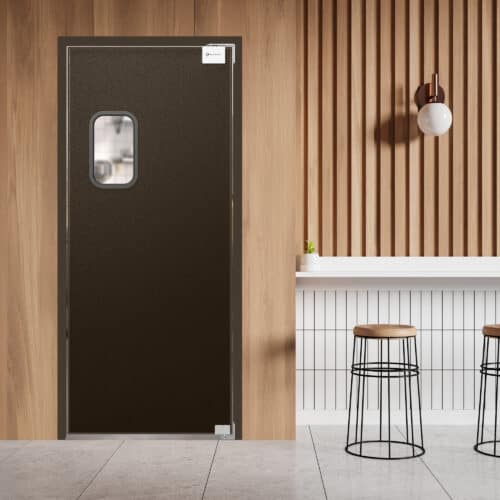 Brown traffic door with a small window set in a wooden paneled wall next to a modern counter with two bar stools.