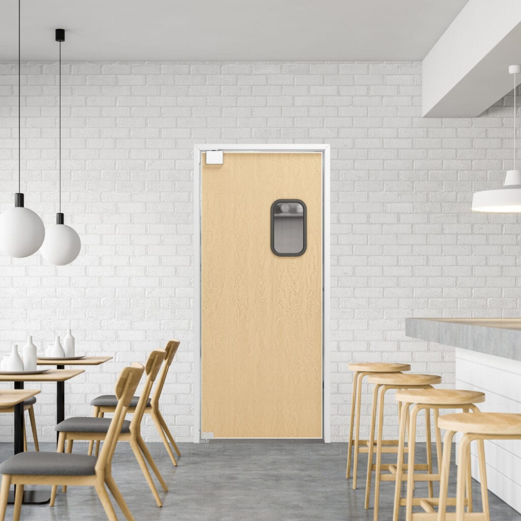 A minimalist cafe interior traffic door with light wood furniture, a smooth bar counter, and a light wood door with a small window, set against a white brick wall.