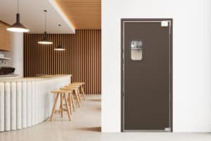 A modern cafe interior with wooden stools and pendant lights, featuring a brown door with a small rectangular window.