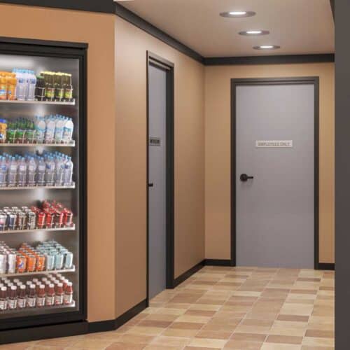 A hallway in a store features a FlexFit™ Field-Adjustable Interior Aluminum Door Frame on the 