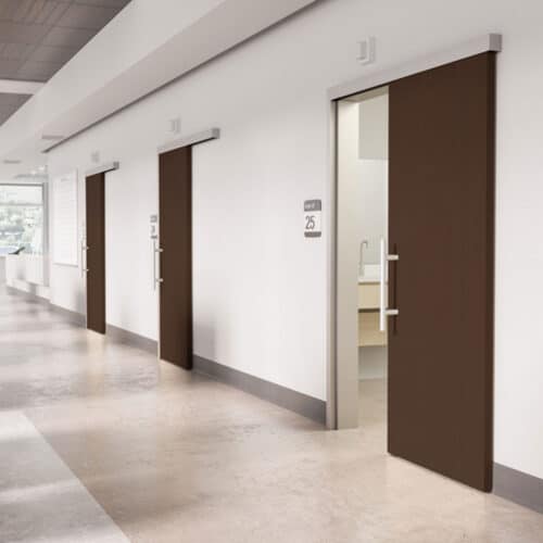 A modern hallway with three closed wood veneer doors and one open door, revealing a white sink inside a room labeled 